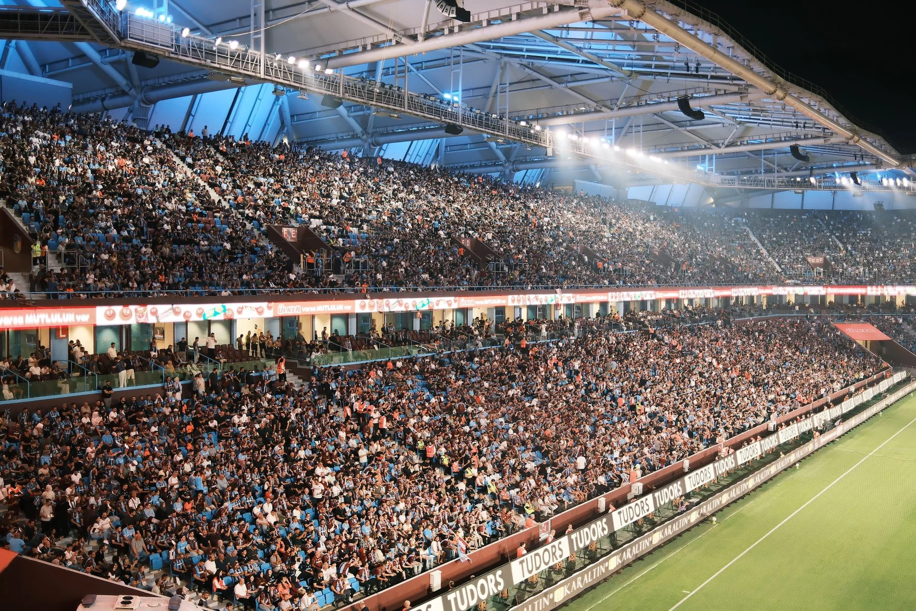 Un estadio de fútbol lleno de espectadores durante un partido nocturno